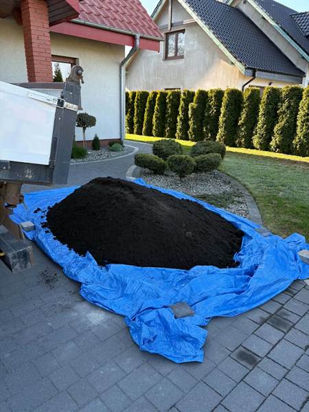 Czarnoziem wysypany na plandekę przed domem